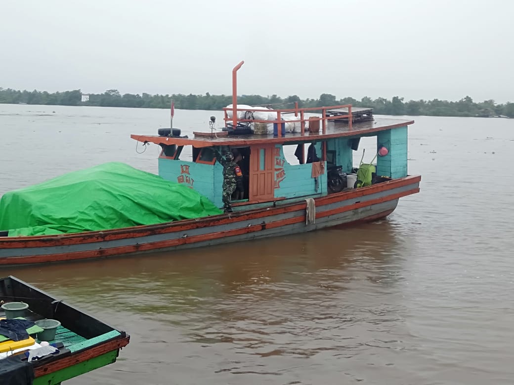 Gunakan Kapal Air, Babinsa Koramil Batu Ampar Kawal Beras Bantuan