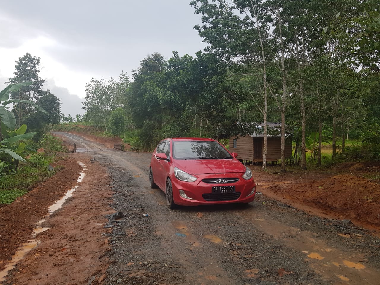 Kali Pertama Jalan Baru Desa Bi-ih Kecamatan Karang Intan Dilintasi Mobil Sedan Merah