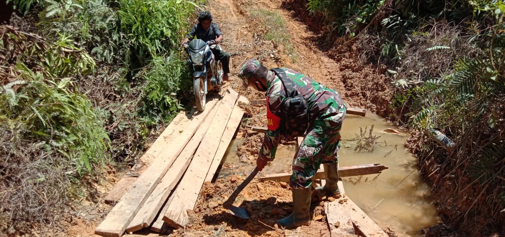 Bersama Warga, Babinsa Muara Kota Perbaiki Jembatan