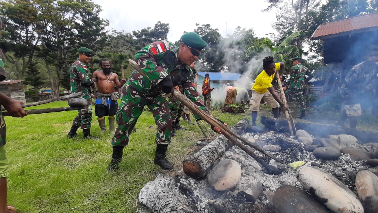 Satgas Yonif Para Raider 432 Kostrad Bakar Batu Bersama Masyarakat Menyambut Hari Raya Natal