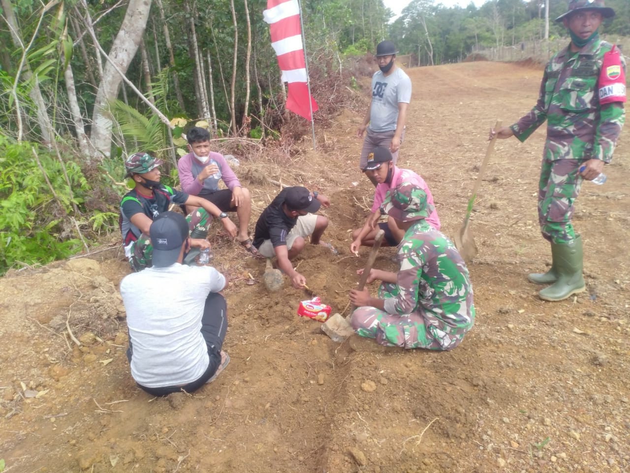 Bersama Warga, Anggota Satgas Nikmati Snack Biskuit Di Lokasi TMMD