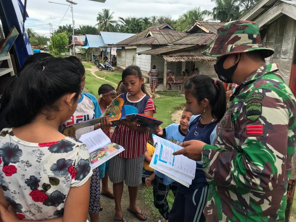 Perpustakaan Keliling Kodim Mentawai, Praka Wawan Ajari Membaca Anak-anak di Lokasi TMMD