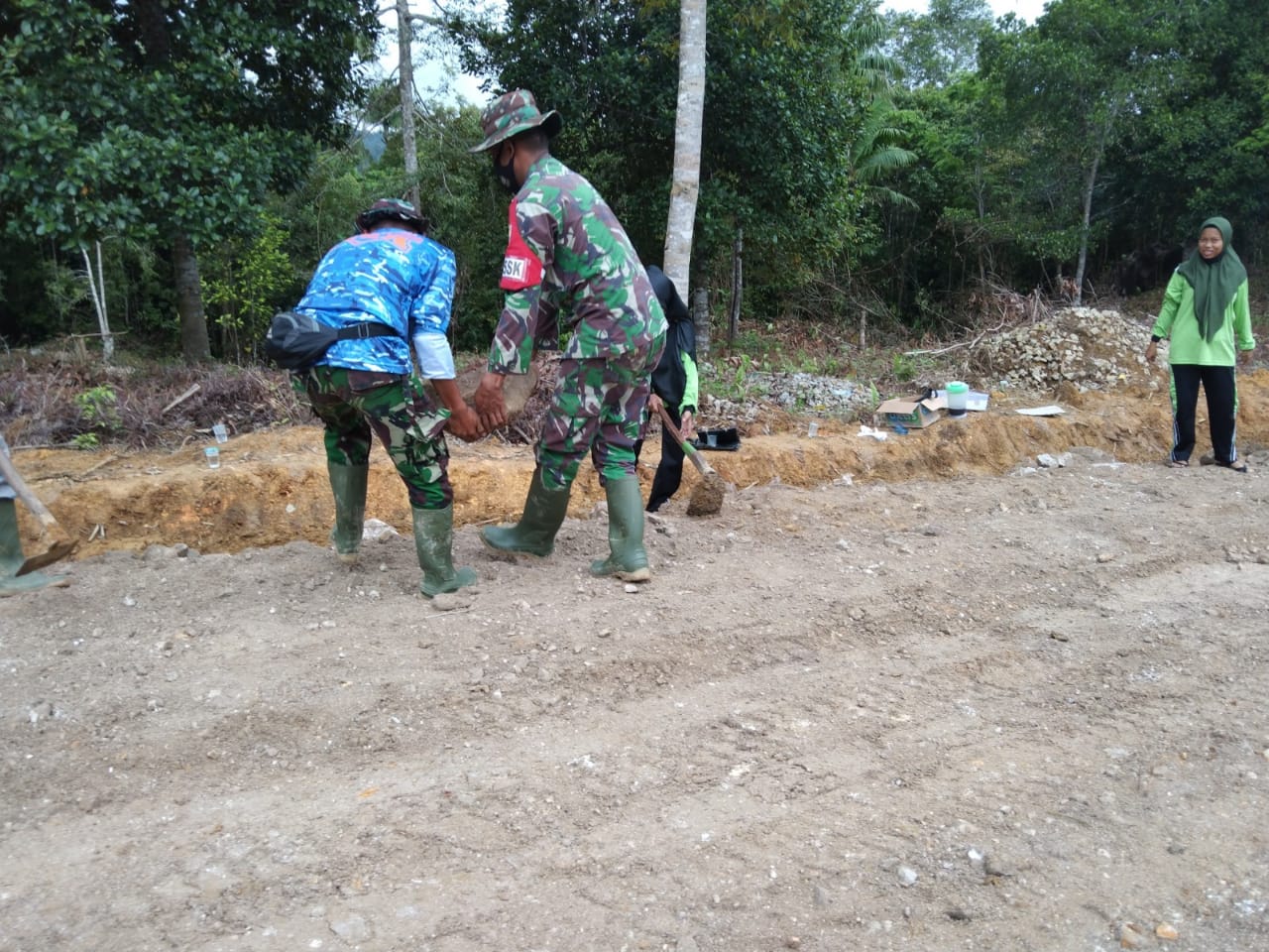 Dan SSK Letda Inf Adi Sofyan Bersama Anggota Satgas Mengangkat Batu