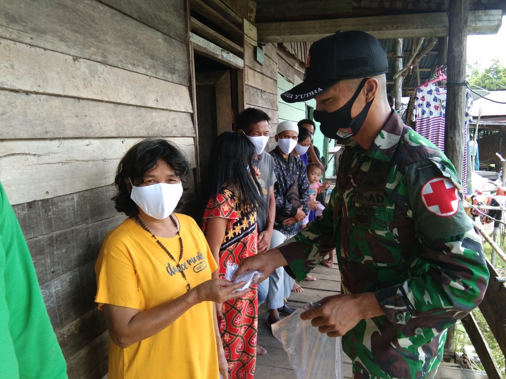 Cegah Penyebaran Covid-19, Satgas Yonif 144/JY Sosialisasikan Prokes dan Bagikan Masker di Perbatasan