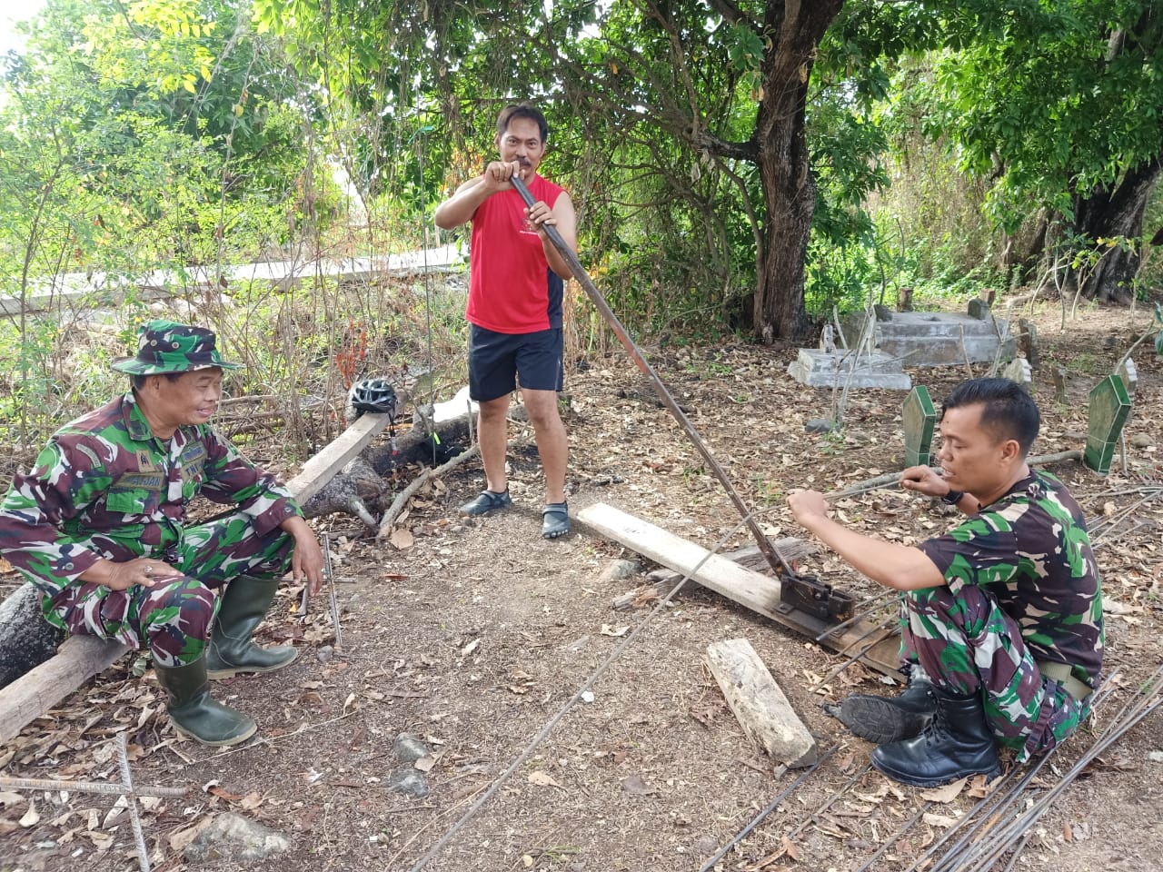 Bersama Warga, Anggota Satgas Laksanakan Pemotongan Besi Untuk Betonisasi Jalan