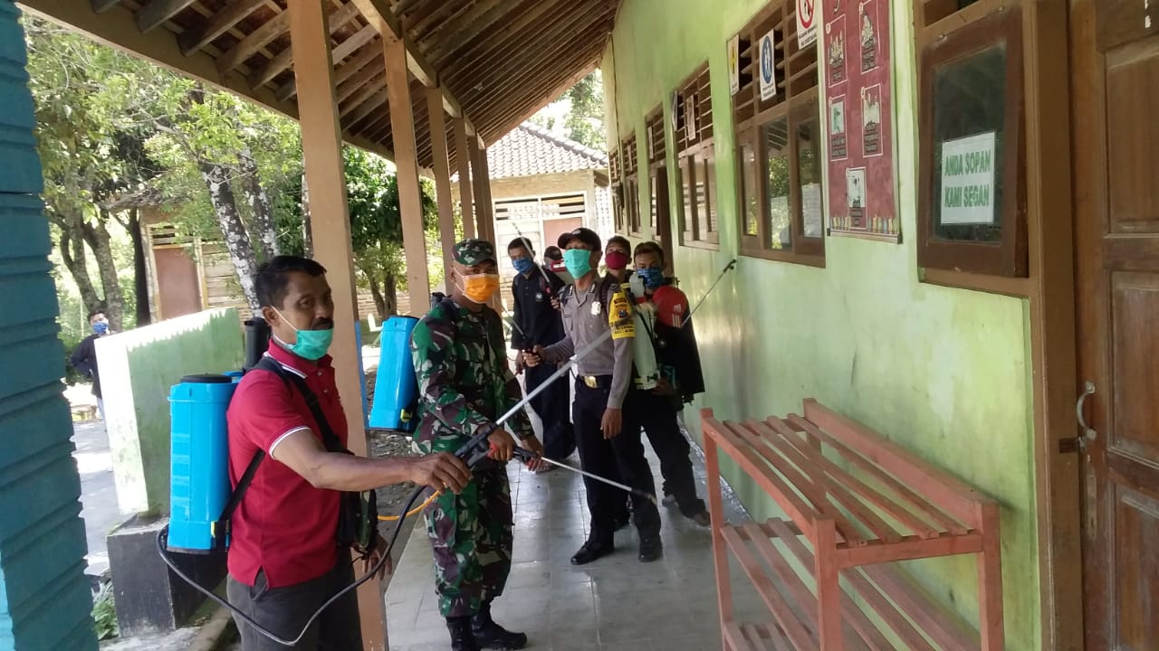 Jelang PTM Babinsa Koramil 0803-07/Kare Lakukan Penyemprotan Disinfektan di Sekolah