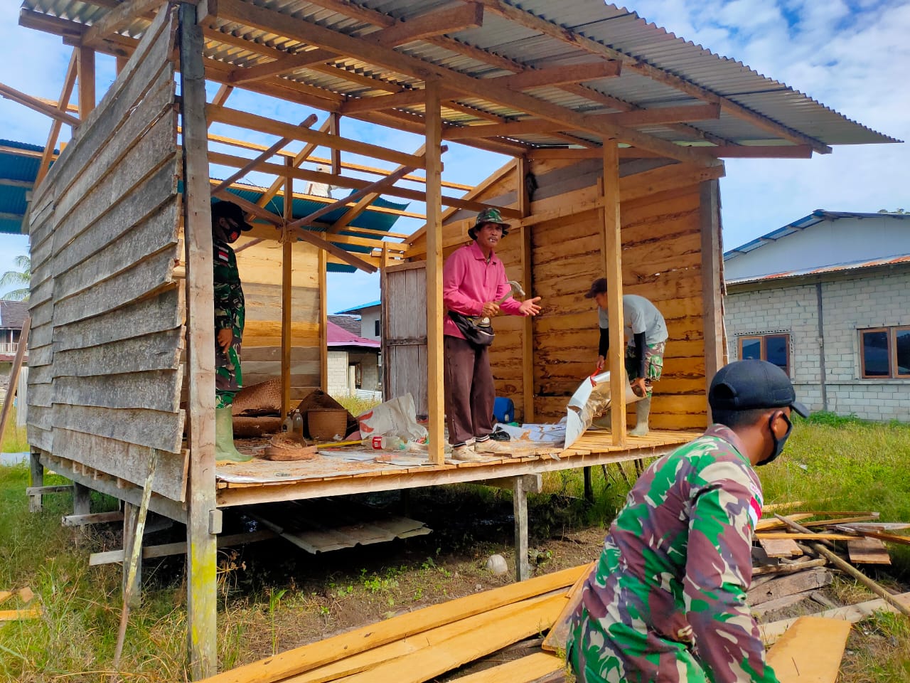 Satgas Yonif 144/JY Bersama Warga Gotong Royong Bangun Balai Adat Desa