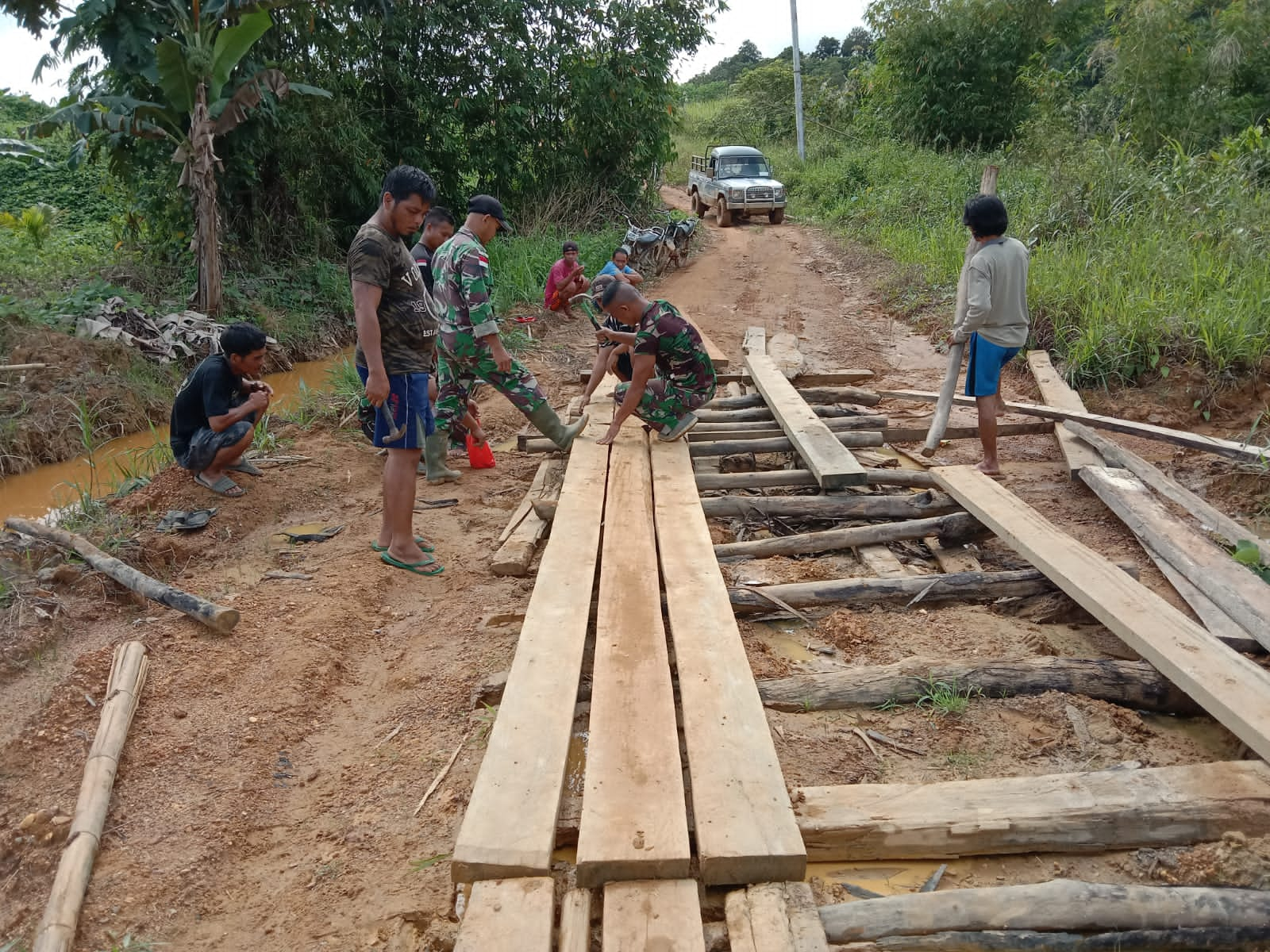 Satgas Yonif 144/JY Bersama Warga Gotong Royong Perbaiki Jalan Desa