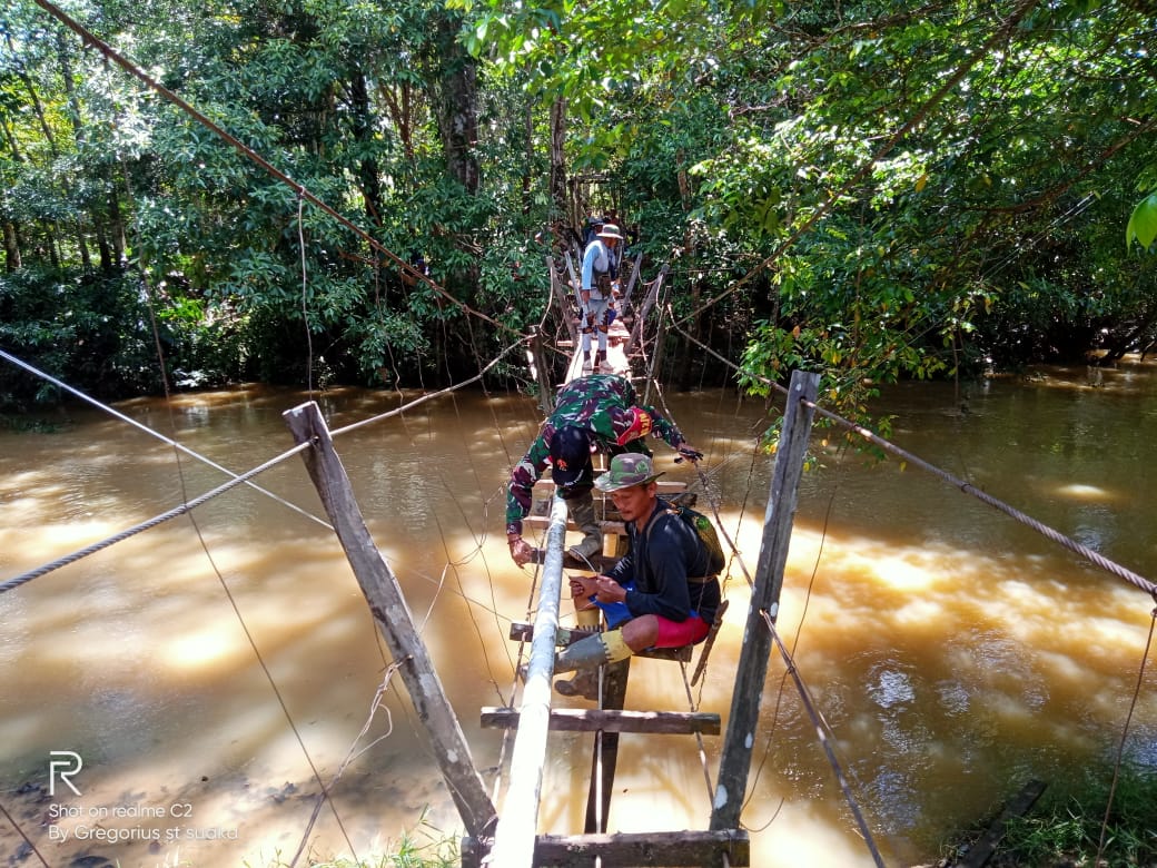 Satgas Yonif 144/JY Bersama Warga, Gotong Royong Perbaiki Jembatan Gantung