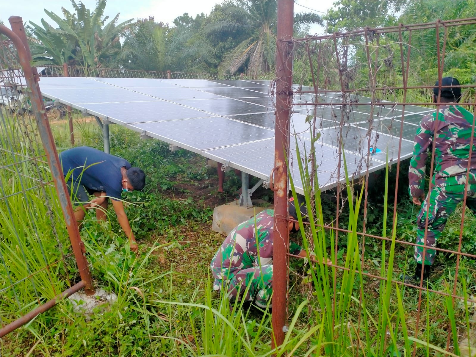 Satgas Yonif 144/JY Gotong Royong Bersihkan PLTS Bersama Warga di Perbatasan