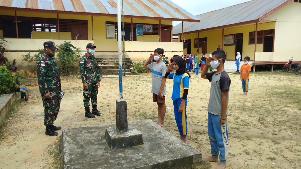 Satgas Yonif 144/JY Bagikan Masker dan Ajarkan Upacara Penaikan Bendera di SDN 01 Perbatasan