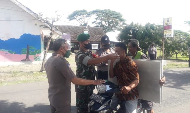 Bersama Tiga Pilar, Anggota Posramil Gerih Bagikan Masker Kepada Masyarakat