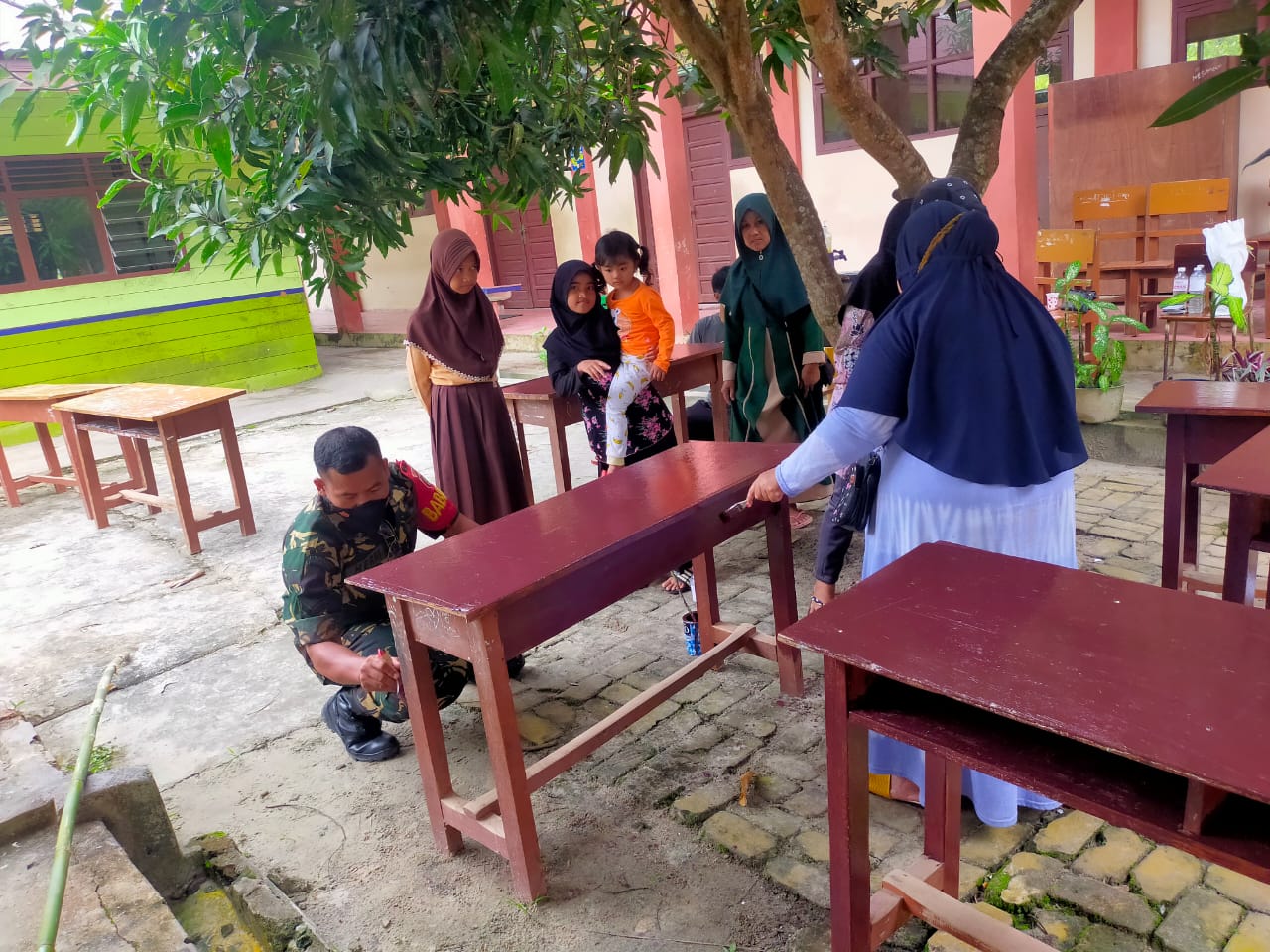 Manfaatkan Hari Libur, Babinsa Tanjung Tengah Bantu Cat Bangku Sekolah SDN 036