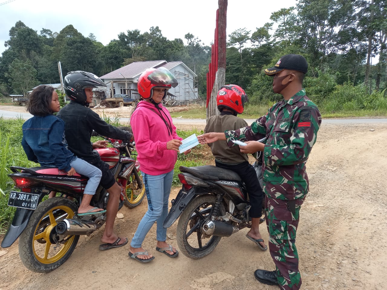 Himbau Masyarakat Tingkatkan Disiplin Prokes, Satgas Pamtas Yonif Mekanis 643/Wns Bagikan Masker