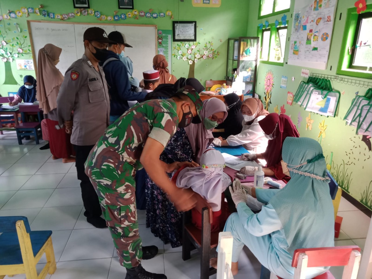 Pastikan Aman, Babinsa Koramil Tipe B 0808/07 Ponggok Dampingi Kegiatan Vaksinasi Anak